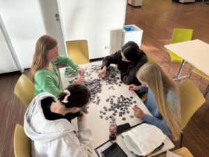 Kindersitzen in einem Kunstmuseum auf dem Boden und hören den Kuratoren zu.