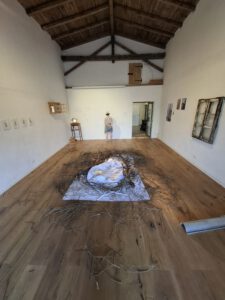 Kindersitzen in einem Kunstmuseum auf dem Boden und hören den Kuratoren zu.